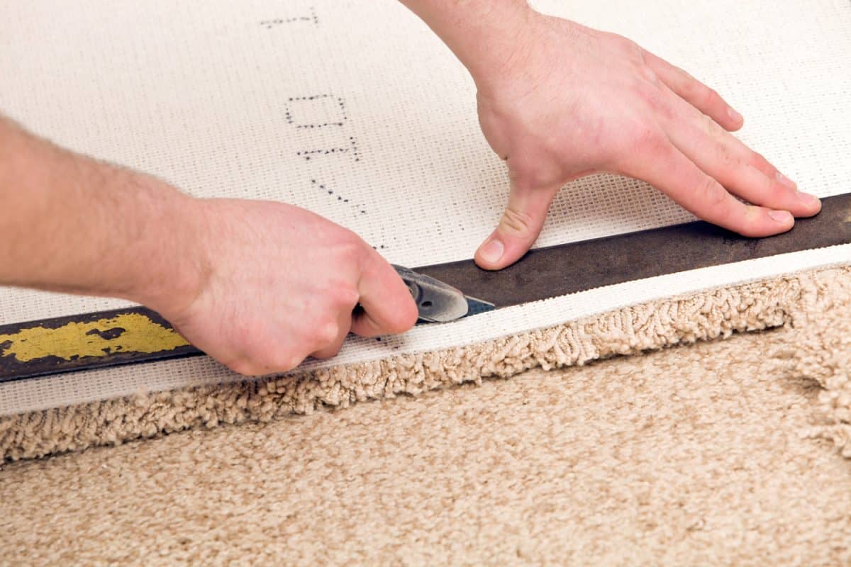Carpet Installer Cutting with Knife and Straight Edge