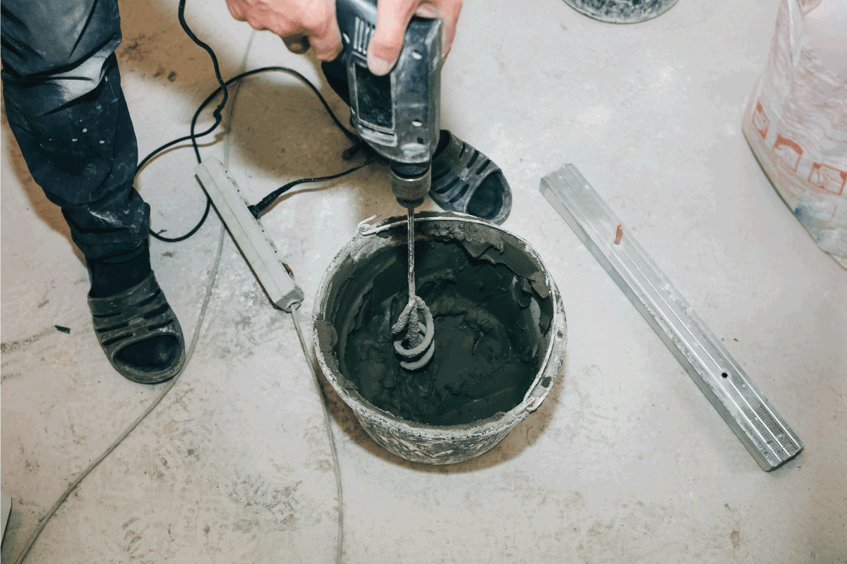 Man is holding paddle mixer in his hands. Maintenance repair works renovation in the flat. mixing tile adhesive. Difference Between Wall And Floor Tile Adhesive - Is There Any