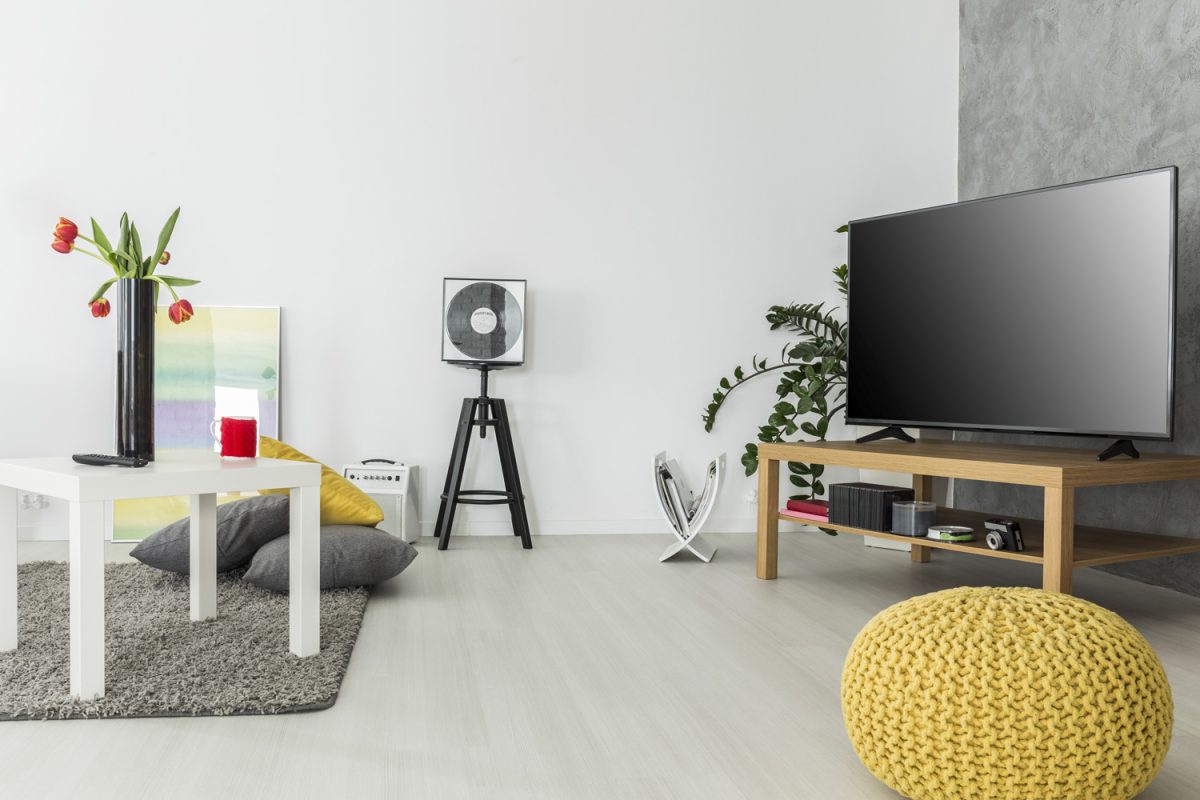 Modern living room with simple but trendy furniture AND a tv set, arranged in grey and yellow