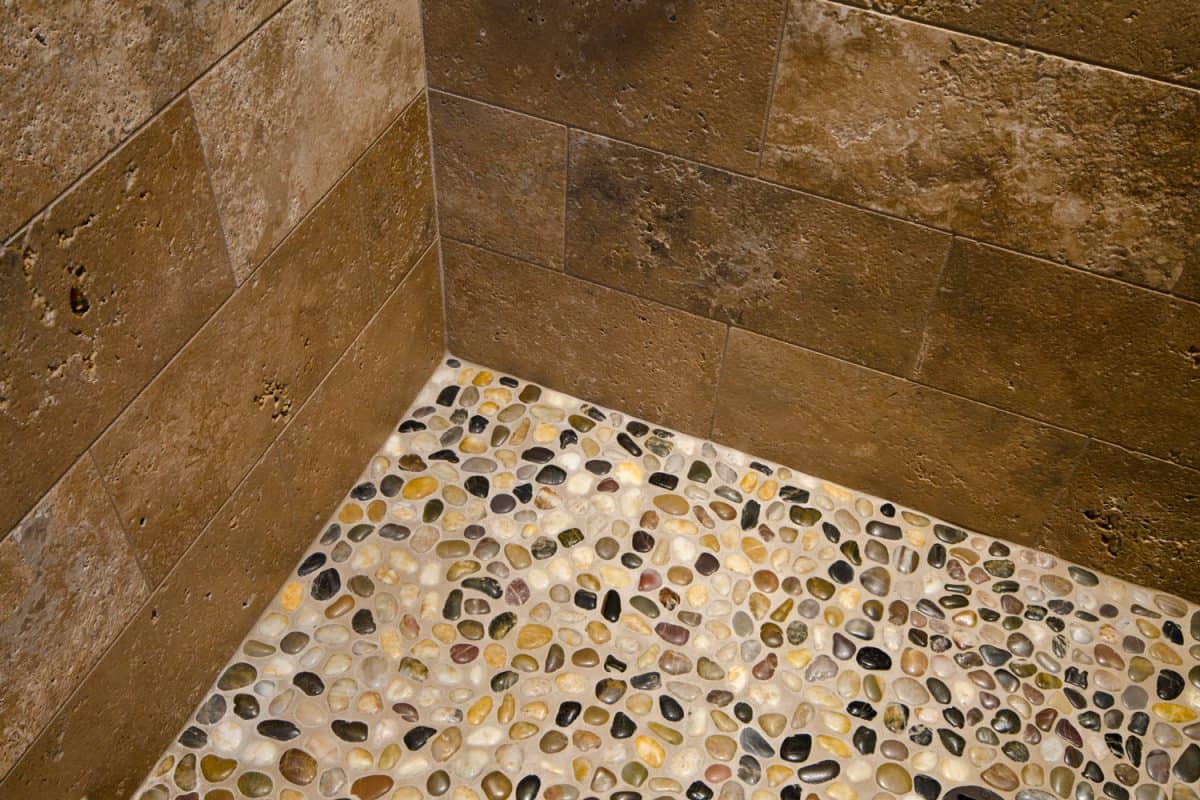 This close up is of a pebble floor in a shower.

