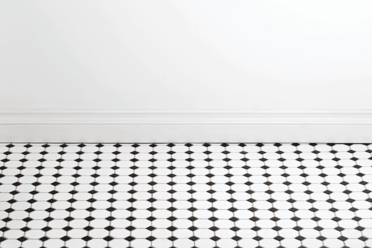 empty white walled bathroom with patterned floor tile and stone baseboard