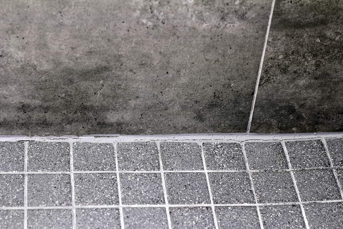 Cracked bathroom shower tile grout corner between wall and floor
