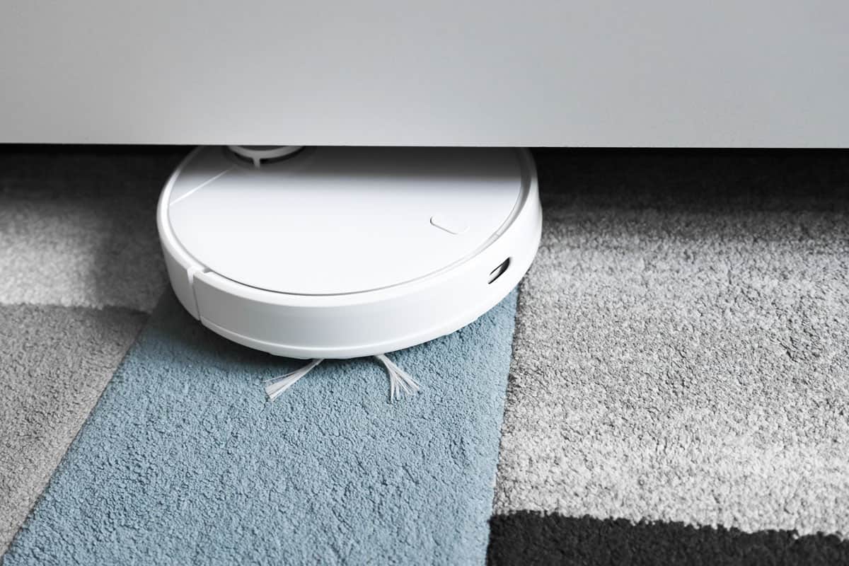Robot vacuum cleaner cleaning the carpet in the room under the bed