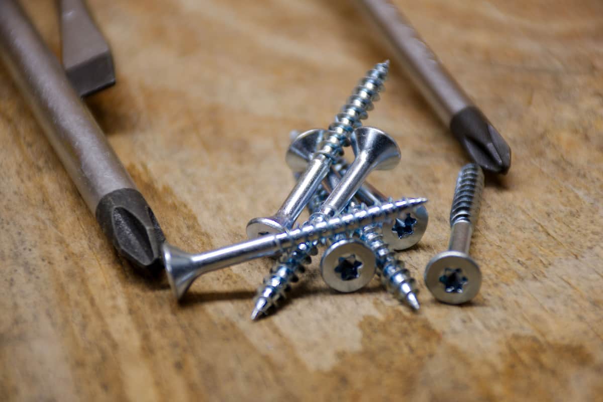 Screwdrivers and screws on rustic wooden table