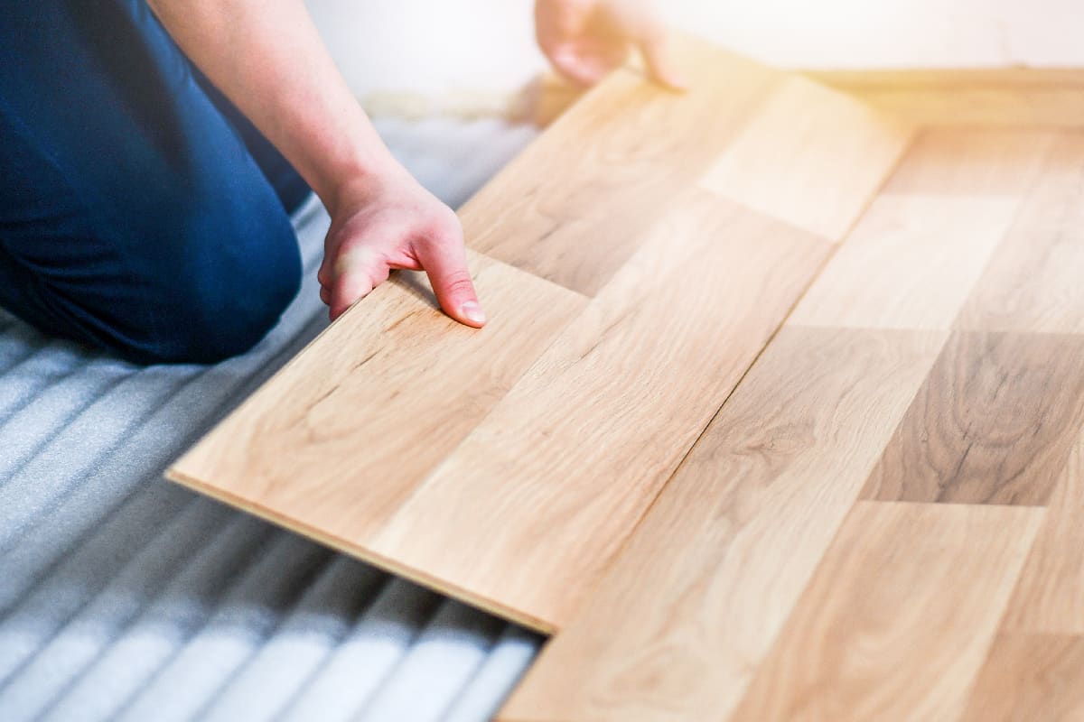 Worker hands installing timber laminate floor