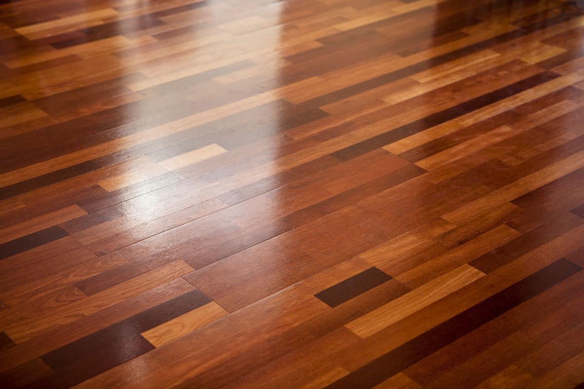a photo of a shiny brown wood floor tile, new wax on wood floor