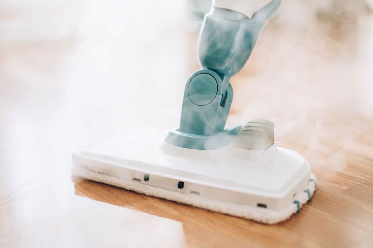 close up photo of a steam mop steaming on the wood tile floor