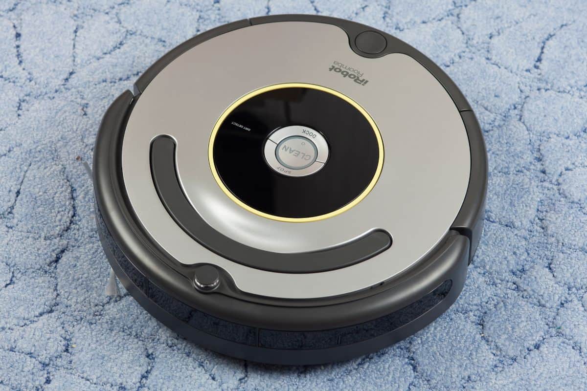 iRobot Roomba 630 Vacuum Cleaning Robot on blue carpet. Studio shot.