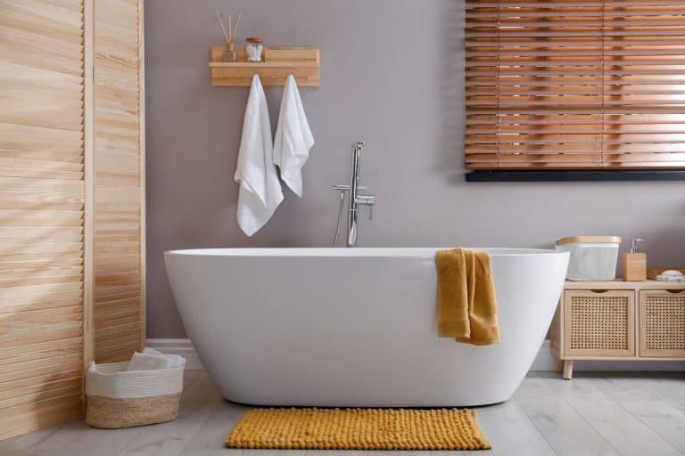 photo of a bath tub on bathroom orange mat on floor near, No Subfloor Under Bathtub—What To Do?