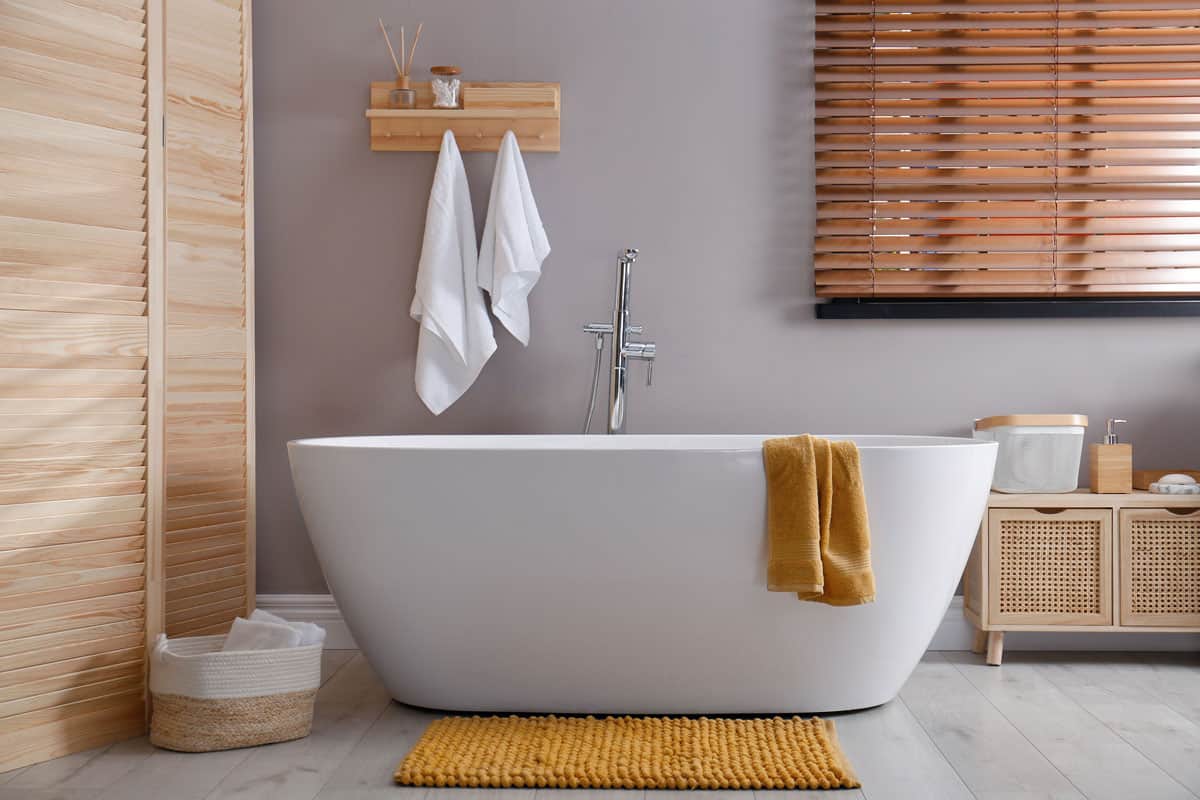 photo of a bath tub on bathroom orange mat on floor near