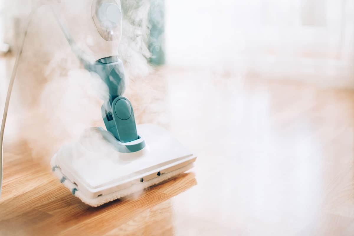 smoking steam mop on the floor to remove dirts and sterilize the germs on it