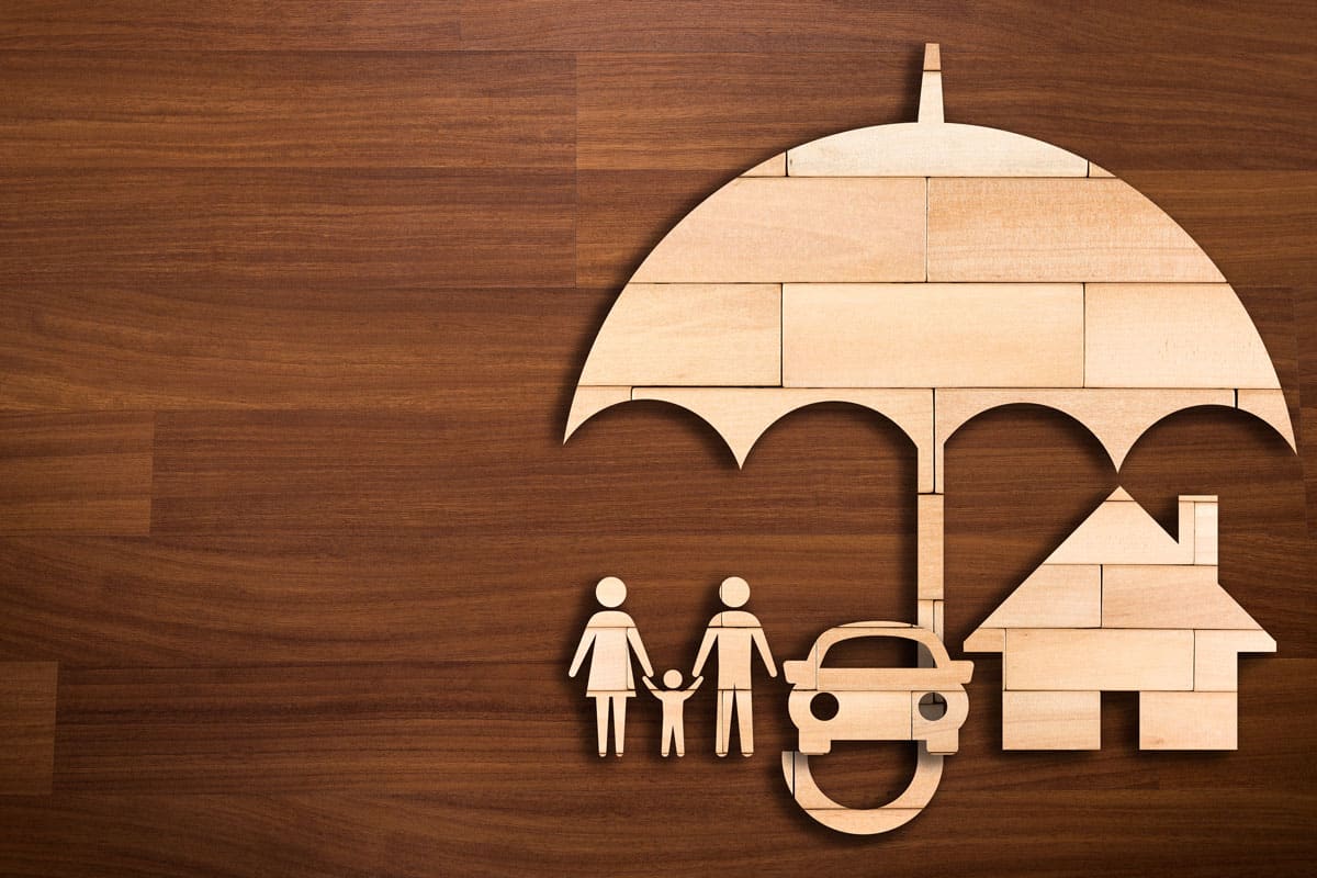wooden family silhouette under a huge big umbrella, a car and house