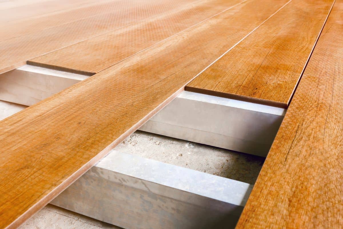 Construction floor installation wooden work flooring wood plank. Timber flooring installation deck board. Repair floor covering. Repair house deck floor renovation home. Timber decking wood floorboard.
