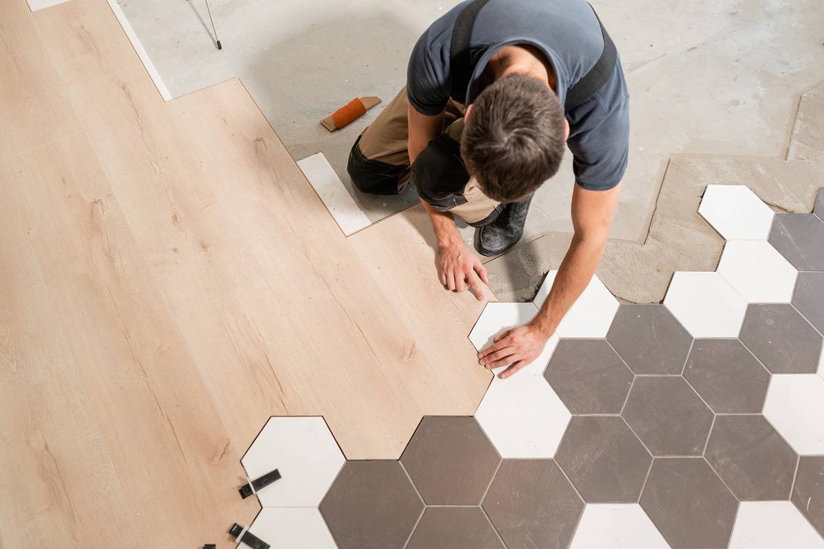 Geometric and Modern - Male worker installing new wooden laminate flooring.