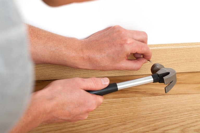 Handyman repairing a skirting board on the floor, Where To Nail Baseboard Trim?