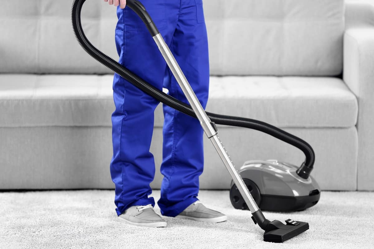 How Much is a Carpet Cleaning Machine - Man cleaning in the flat with vacuum cleaner