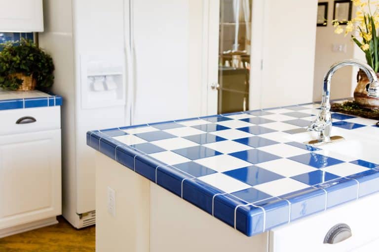 A modern kitchen interior with checkered white and blue tile, Can You Use Floor Tiles On Countertops?
