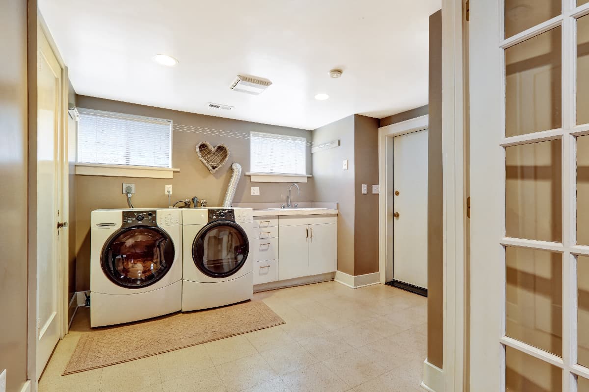 Spacious laundry room with tile floor and light grey wall
