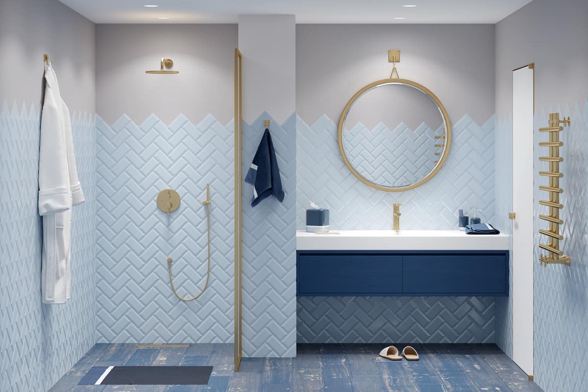 minimalist blue and white bathroom one round mirror with gold frame in on the tiled white wall.
