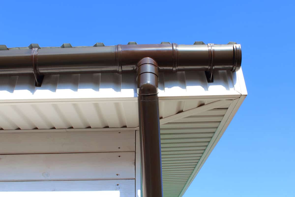 photo of a Plastic drainpipe on the roof of the house. Close-up. Background