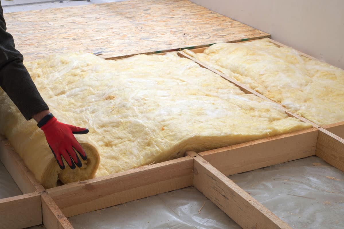 work composed of mineral wool insulation in the floor, floor heating insulation , warm house, eco-friendly insulation, a builder at work