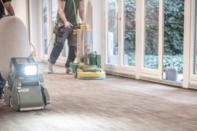 Craftsmen sand a parquet floor, How To Dispose Of Floor Sanding Dust