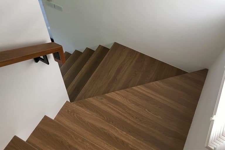 A vinyl stair with wood hand rail on a wall, Can Lifeproof Flooring Be Used On Stairs?