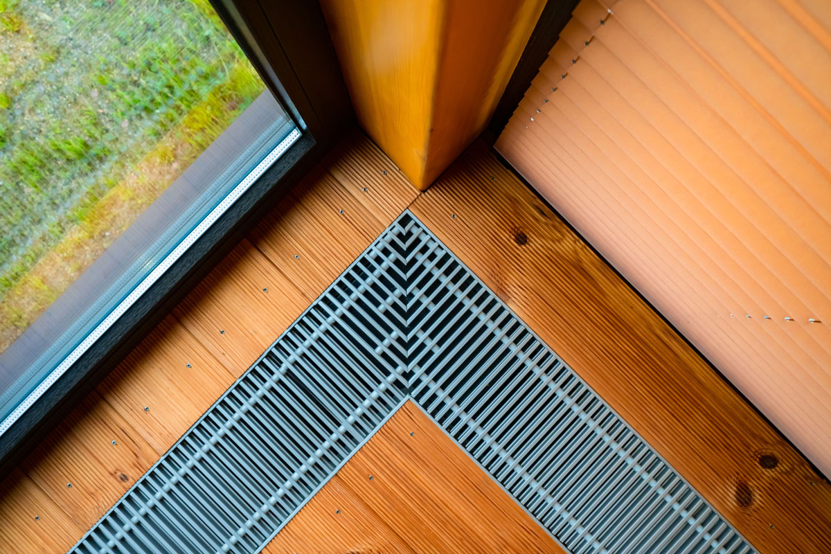 Heating in the floor of the cottage. Ventilation grilles in the floor