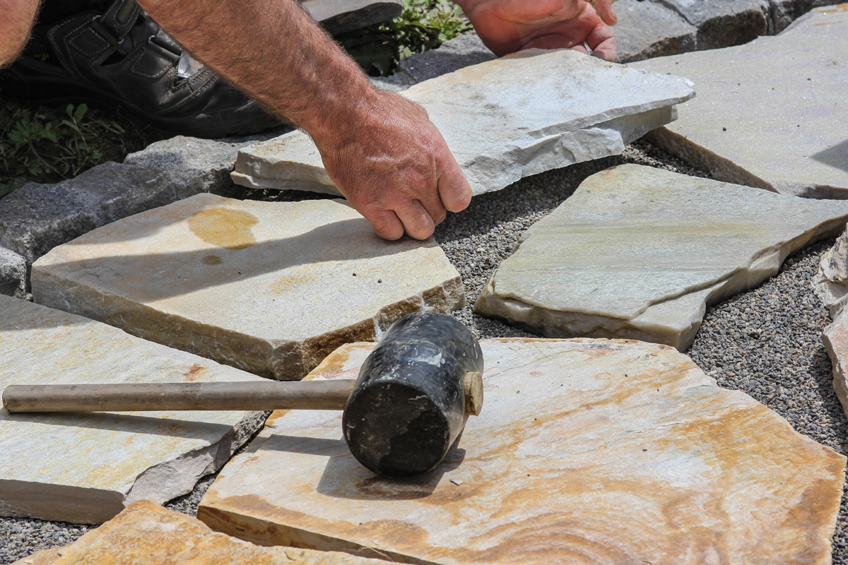 Worker with paver's dressing hammer
