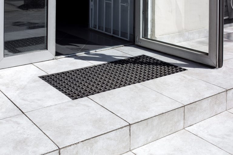 threshold made of light gray ceramic tiles with steps at the entrance to the store with a foot mat and an open glass door at the facade of an office building close-up, nobody., How To Remove Marble Threshold
